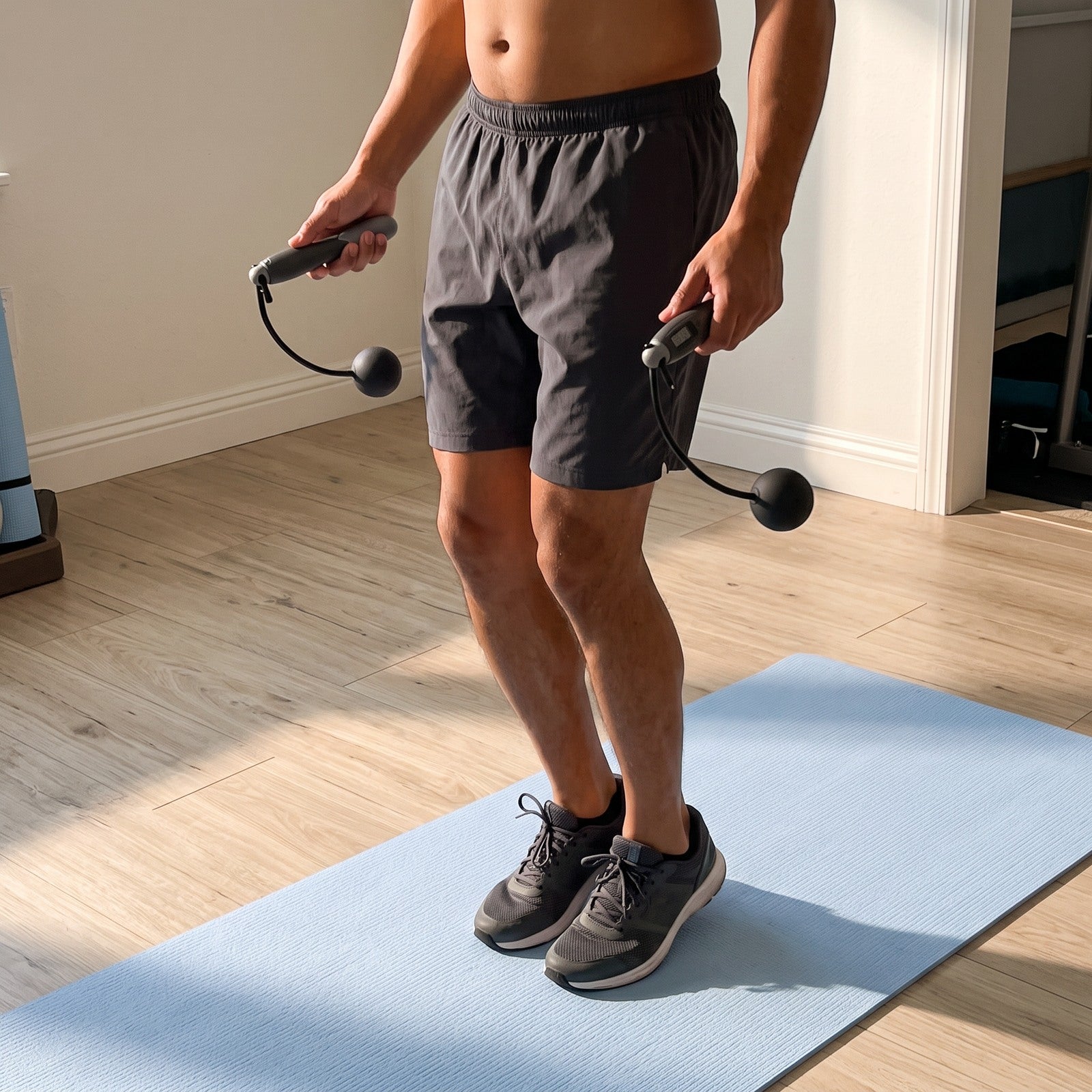 Man using Black rope in a spare room, seen from a low side angle